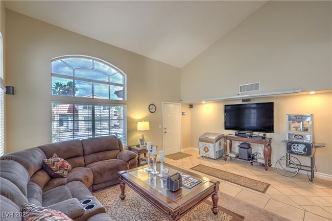 Living room with high vaulted ceiling and light tile patterned flooring | Image 5