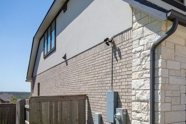 View of side of property with stone siding, stucco siding, and fence | Image 31