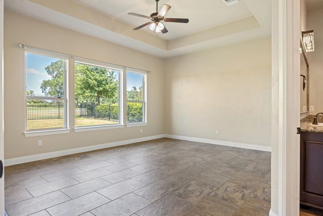 Spare room featuring a raised ceiling and a ceiling fan | Image 27