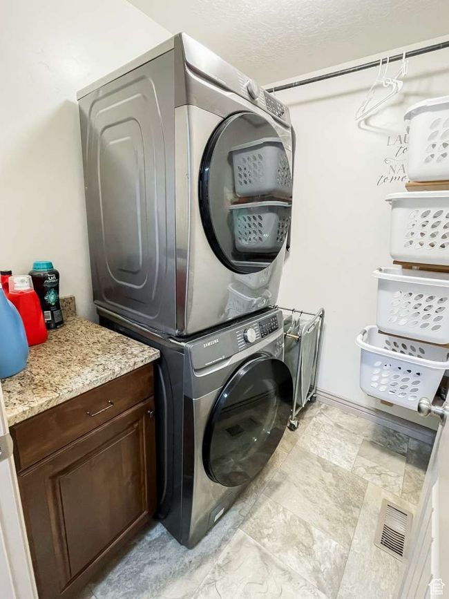 Laundry room featuring stacked washer and clothes dryer | Image 7