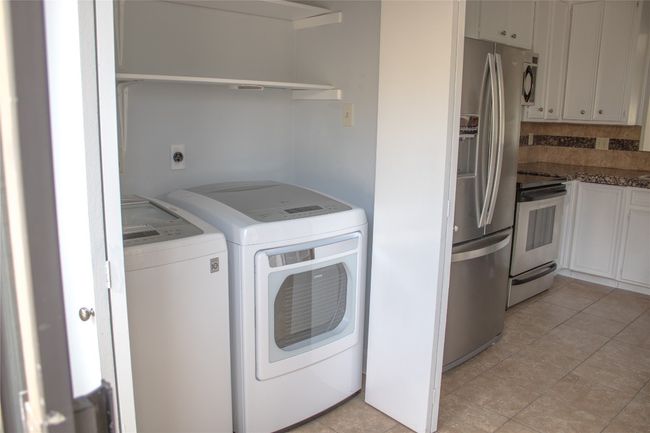 Washroom featuring washing machine and dryer, laundry area, and light tile patterned floors | Image 7