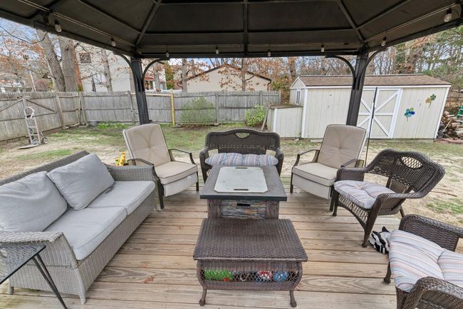 Deck with a storage shed, a gazebo, a fenced backyard, and an outdoor living space | Image 26