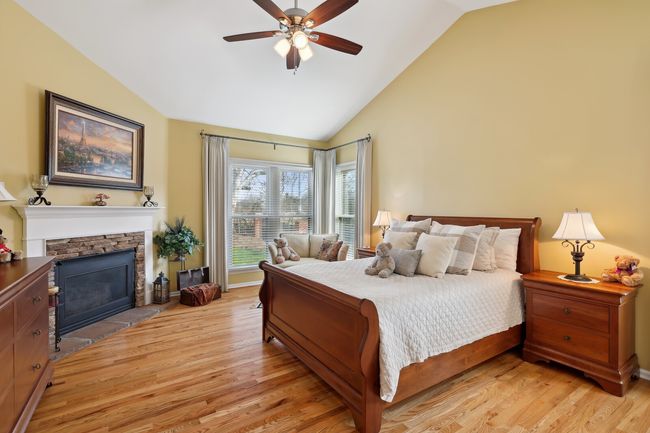 Primary suite has a vaulted ceiling which makes this large room feel even bigger! Corner fireplace has had a facelift with new stone and tile hearth. | Image 20