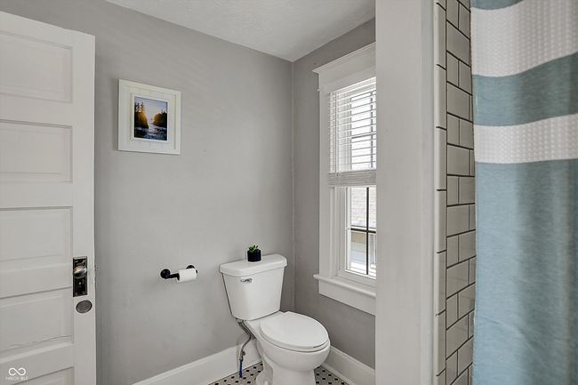 bathroom featuring tile patterned floors, baseboards, a shower with shower curtain, and toilet | Image 32