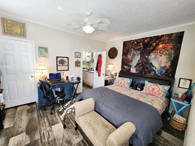 Bedroom featuring hardwood / wood-style floors, ensuite bath, ceiling fan, ornamental molding, and a textured ceiling | Image 14