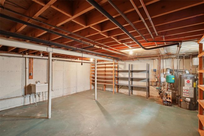 Unfinished below grade area with a sink and gas water heater | Image 34