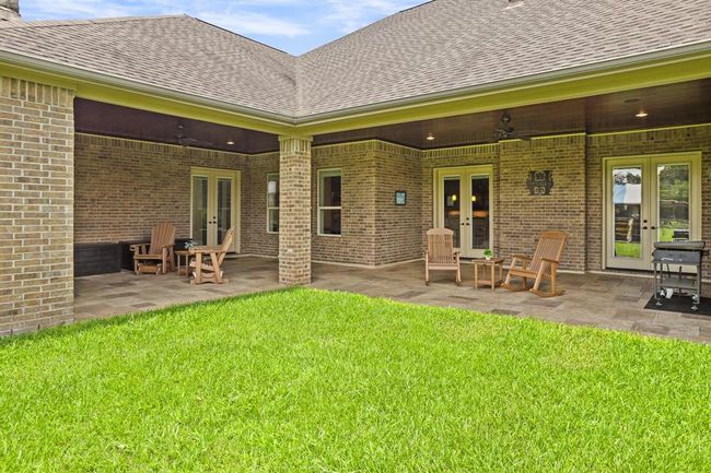 This large Back Patio acts as two different outdoor living spaces, making it fun to entertain and relax outdoors. Recessed lighting keeps the space well lit in the evenings, and the two ceiling fans help keep the air circulating on those hot summer days. | Image 43