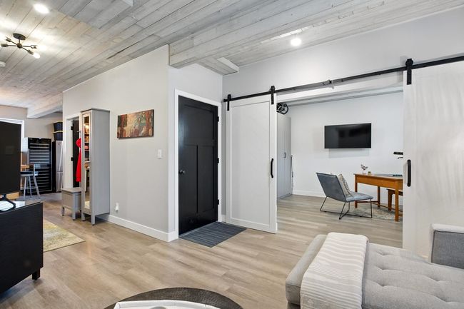 Living room featuring light wood-type flooring, a barn door, and baseboards | Image 27