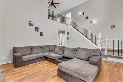 Living room with ceiling fan, hardwood / wood-style floors, and a towering ceiling | Image 2