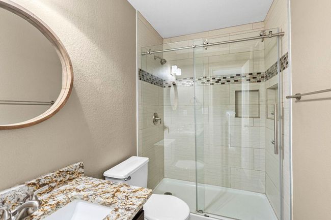 Full bathroom with vanity, a stall shower, and a textured wall | Image 17