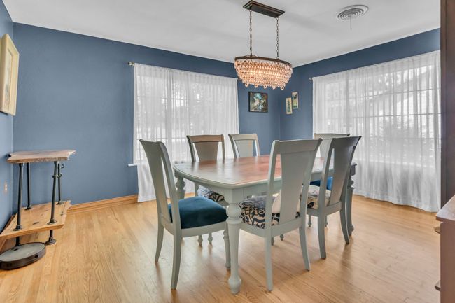 Dining area with a chandelier and wood finished floors | Image 10