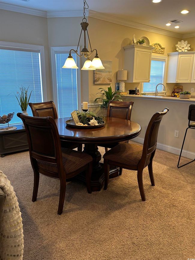 Dining room featuring light carpet, visible vents, crown molding, and recessed lighting | Image 5
