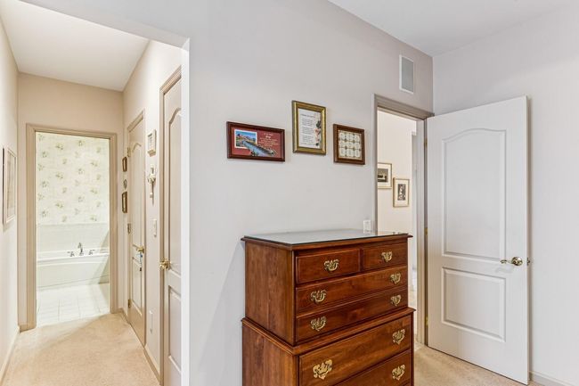 Hallway featuring light colored carpet and visible vents | Image 16