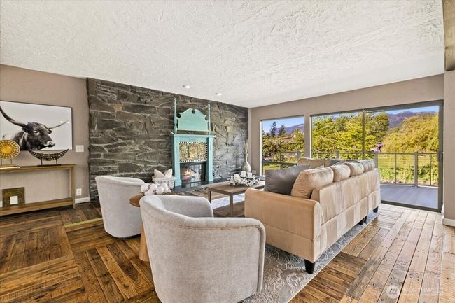 Floor to ceiling stone fireplace. Take in the incredible views from the living room every morning. Oversized glass sliding doors leads to the back deck. | Image 9