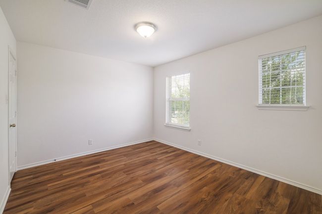 Empty room featuring dark wood-style floors, visible vents, and baseboards | Image 25