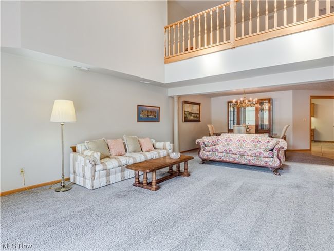 Living room featuring a high ceiling and light carpet | Image 12