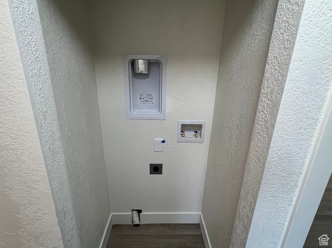 Laundry area featuring electric dryer hookup, wood finished floors, washer hookup, and a textured wall | Image 25