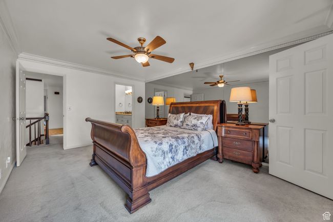 Bedroom featuring crown molding, ceiling fan, ensuite bathroom, carpet flooring, and baseboards | Image 18