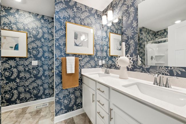 (Photo of decorated model, actual home's finishes may vary slightly) The owner's bathroom offers a double-vanity with quartz countertops, a linen closet, and shower. | Image 9