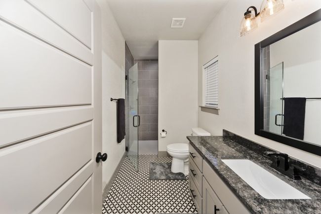 Full bath with vanity, tile patterned floors, toilet, and a shower stall | Image 11