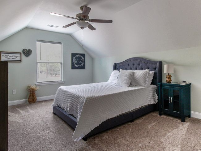 Bedroom with ceiling fan, carpet flooring, and vaulted ceiling | Image 23