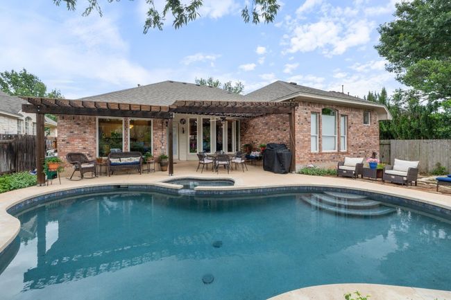 View of pool featuring a pergola, fenced backyard, outdoor dining area, and a pool / hot tub. | Image 32