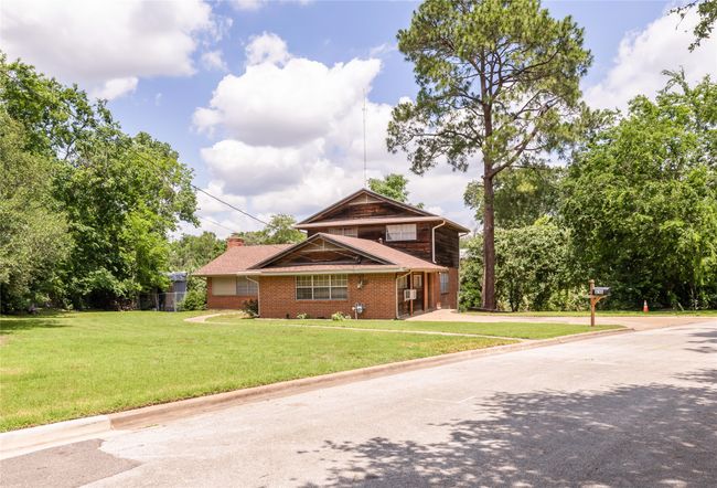View of front facade featuring a front yard, brick siding and large trees | Image 22