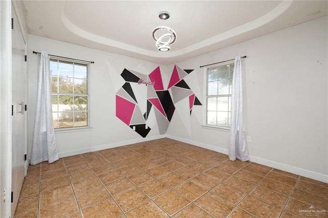 Tiled empty room featuring a tray ceiling | Image 9