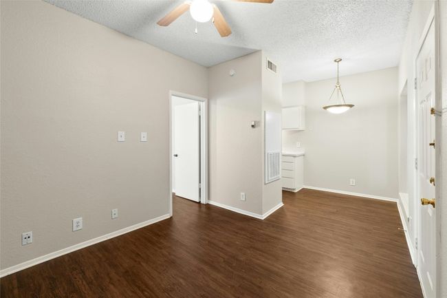 Unfurnished room with dark wood finished floors, baseboards, visible vents, a ceiling fan, and a textured ceiling | Image 8