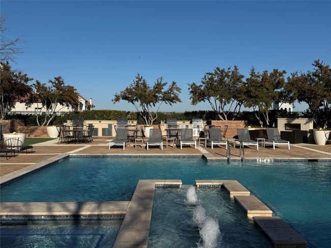 View of swimming pool featuring an in ground hot tub, pool water feature, and a patio area | Image 20
