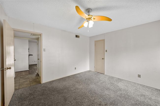 Spare room featuring carpet floors, ceiling fan, and a textured ceiling | Image 10