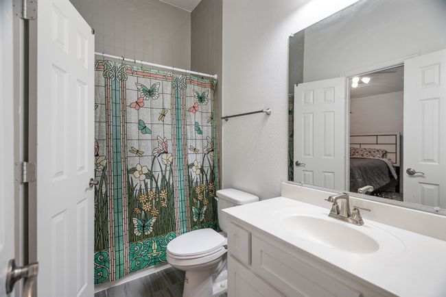 Full bath featuring vanity, ensuite bathroom, a shower with shower curtain, and a textured wall | Image 34