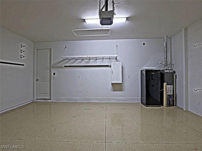 Garage with water heater, baseboards, and a garage door opener | Image 29
