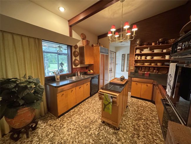 Kitchen with dishwasher, dark countertops, a sink, a chandelier, and beam ceiling | Image 28