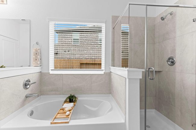 The primary bathroom also includes a deep soaking tub and separate glass-enclosed shower with tile surround—perfect for relaxing after a long day. **Image Representative of Plan Only and May Vary as Built**. | Image 22