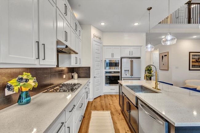 A chef's delight: kitchen with gas cook top, farm sink, quartz counter throughout the kitchen, and a walk-in pantry. | Image 14