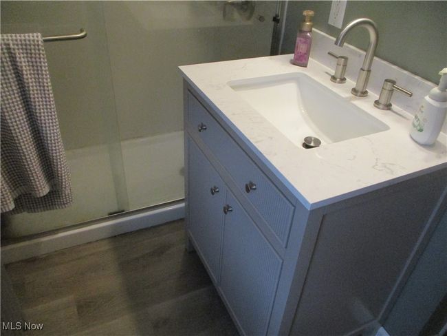 Bathroom featuring vanity, hardwood / wood-style floors, and a shower with door | Image 16