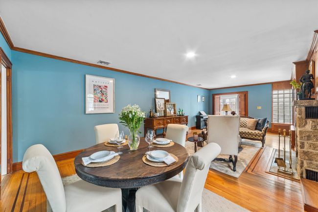 Dining room with ornamental molding, a stone fireplace, wood finished floors | Image 10