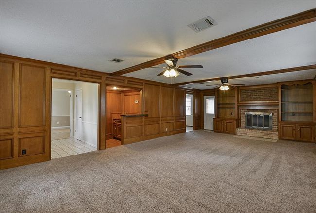 Living room features wood paneling, brick fireplace, and a wet bar. | Image 17