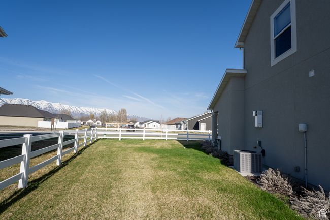 View of yard featuring central air condition unit, a fenced backyard, and a mountain view | Image 23