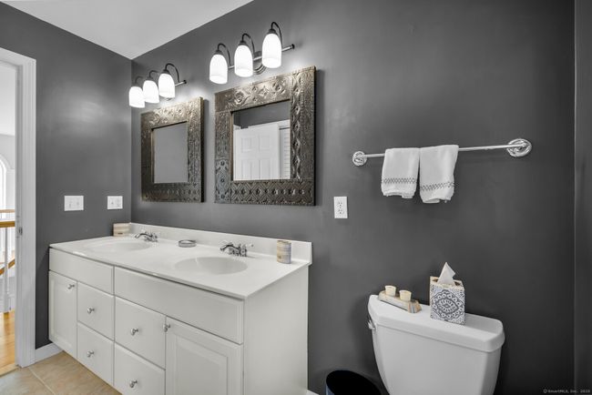 A second full bath serves the two bedrooms. Tile floor, dual sink vanity, combination tub/shower, and linen closet. | Image 23