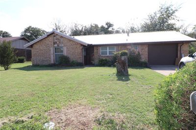 Ranch-style house featuring a garage and a front lawn | Image 2