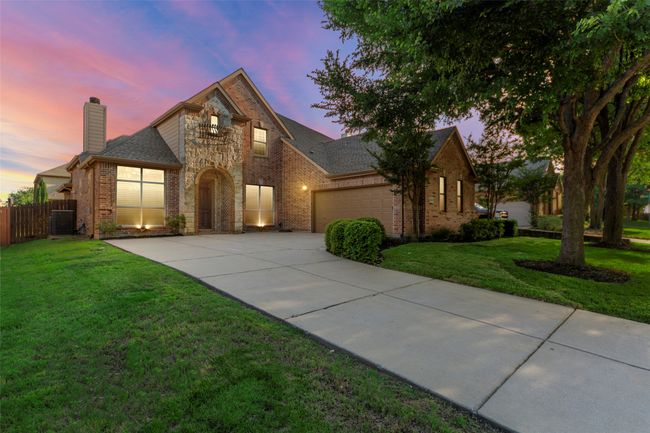 View of front of house with brick siding, a chimney, driveway, a garage, and cooling unit | Image 5