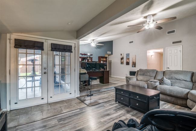 Living area featuring vaulted ceiling, french doors, a ceiling fan, and wood finished floors | Image 6