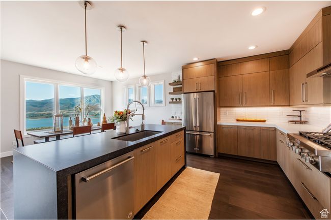 Kitchen featuring stainless steel appliances, a kitchen island with sink, dark wood-type flooring, sink, and a water and mountain view | Image 8