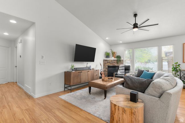 Living area featuring a ceiling fan, light wood-type flooring, lofted ceiling, large windows, and recessed lighting | Image 7