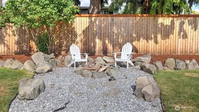 A firepit is featured in a separate backyard area, surrounded by decorative rocks for added style. It’s perfect for cozy late-night gatherings—whether making s’mores or simply enjoying the warmth under the stars | Image 33