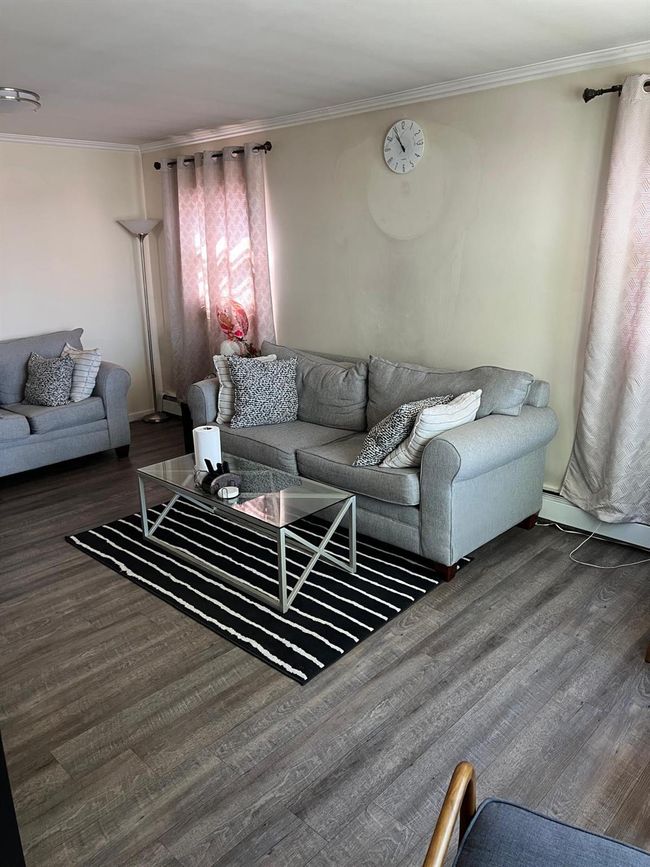 Living area with ornamental molding and wood finished floors | Image 5