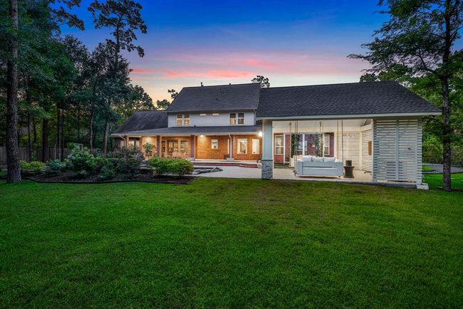 A picturesque backdrop with a spacious covered patio is ideal for entertaining or relaxing. Enjoy evenings on the inviting porch swing under the charming pergola. A seamless blend of comfort, elegance, and outdoor living at its finest. | Image 46