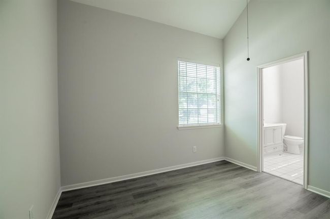 3rd bedroom showcases a bright, minimalist room and laminate flooring. It features a window for natural light. | Image 35